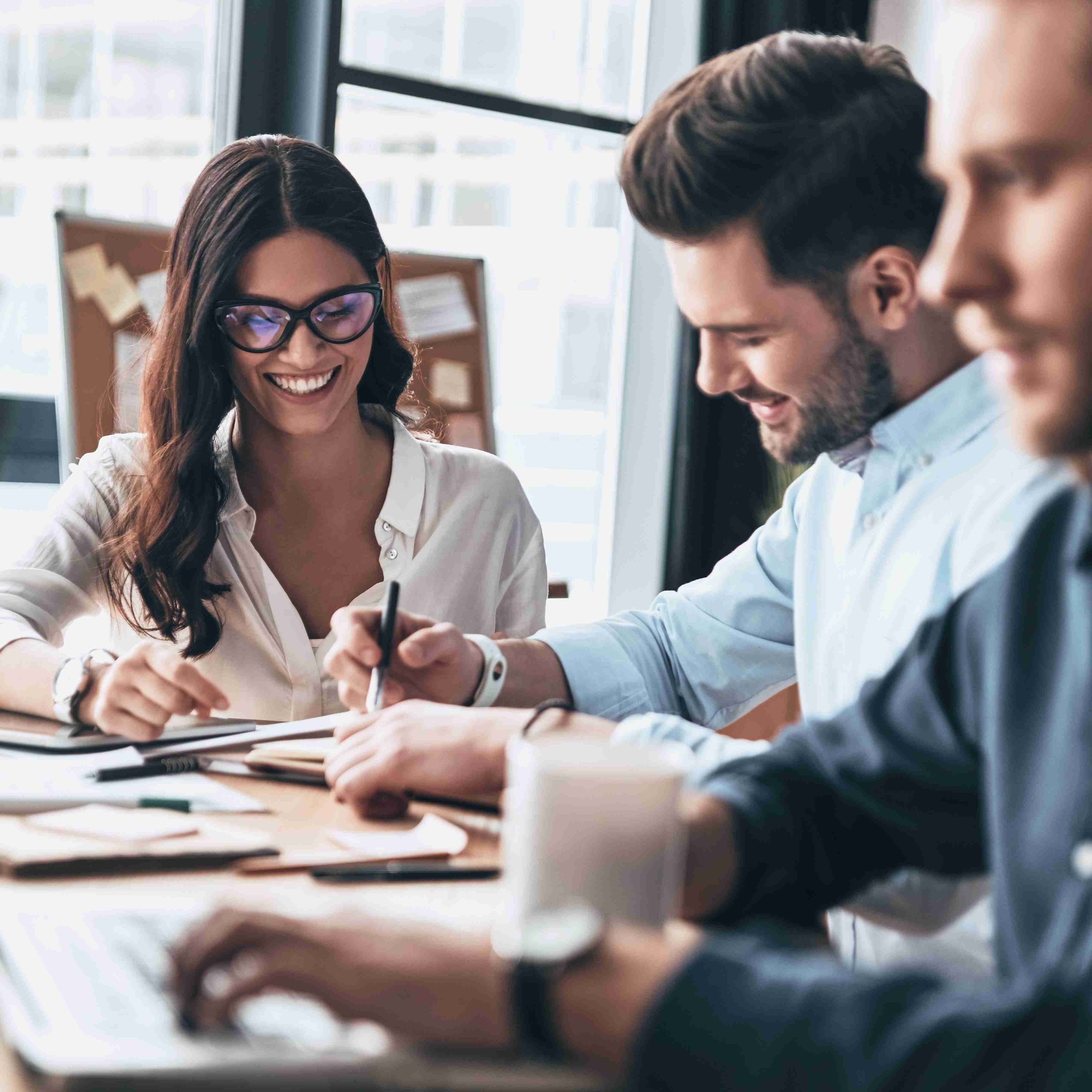 Three IT Professionals working on project at their shared desk